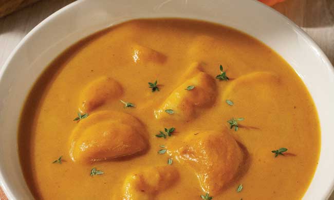 a bowl of pierogi soup with some herbs